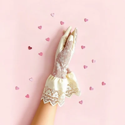 coquette pfp — lace gloves folded, blush pink and cream, tiny scattered hearts